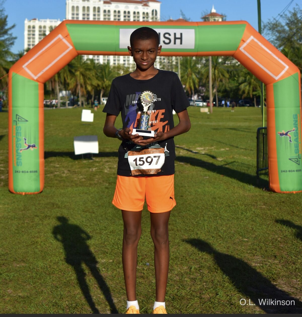 A young runner with his trophy at the finish line