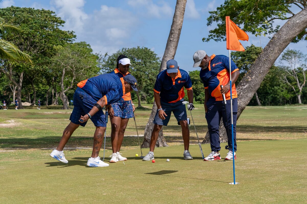 Global Sun Integration teammates lining up a putt during the tournament